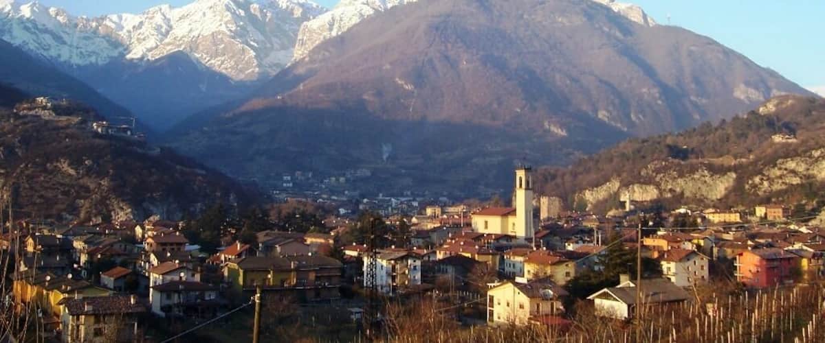 A town nestled between mountains with snow-capped peaks in the background.