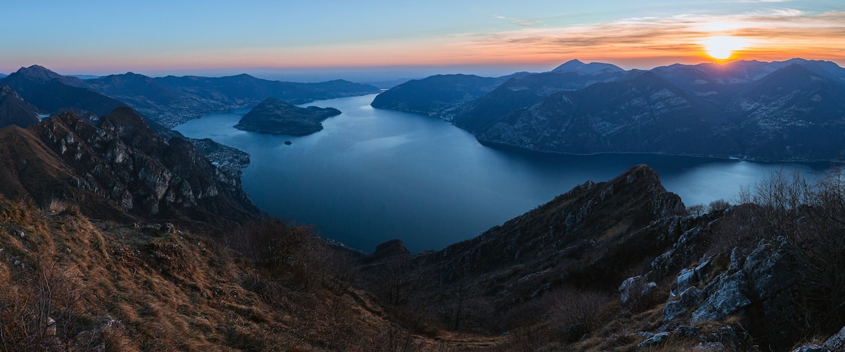 View of Lake Iseo at sunset, with the alps framing it, near the town of Zone, Italy - February 2022.