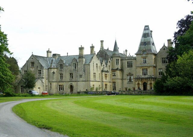 A large, historic building with multiple chimneys and a distinctive tower.