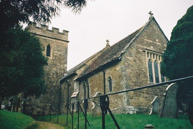 A stone church with a tower and a large window.