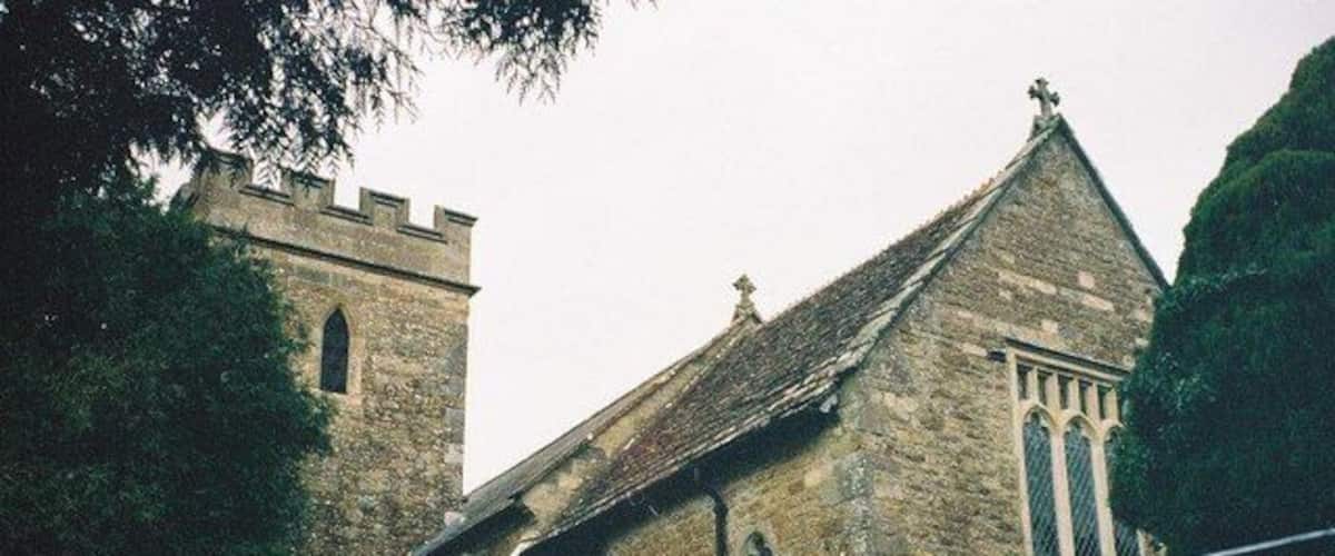 A stone church with a tower and a large window.
