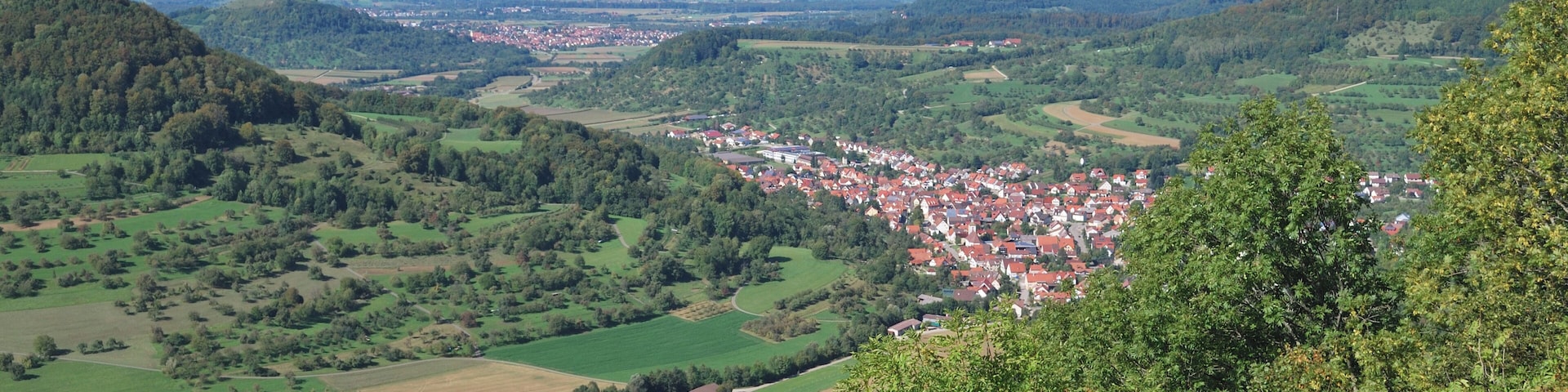 Un valle con una ciudad rodeada de colinas y campos.