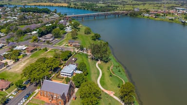A river with a bridge, a church, and surrounding greenery.