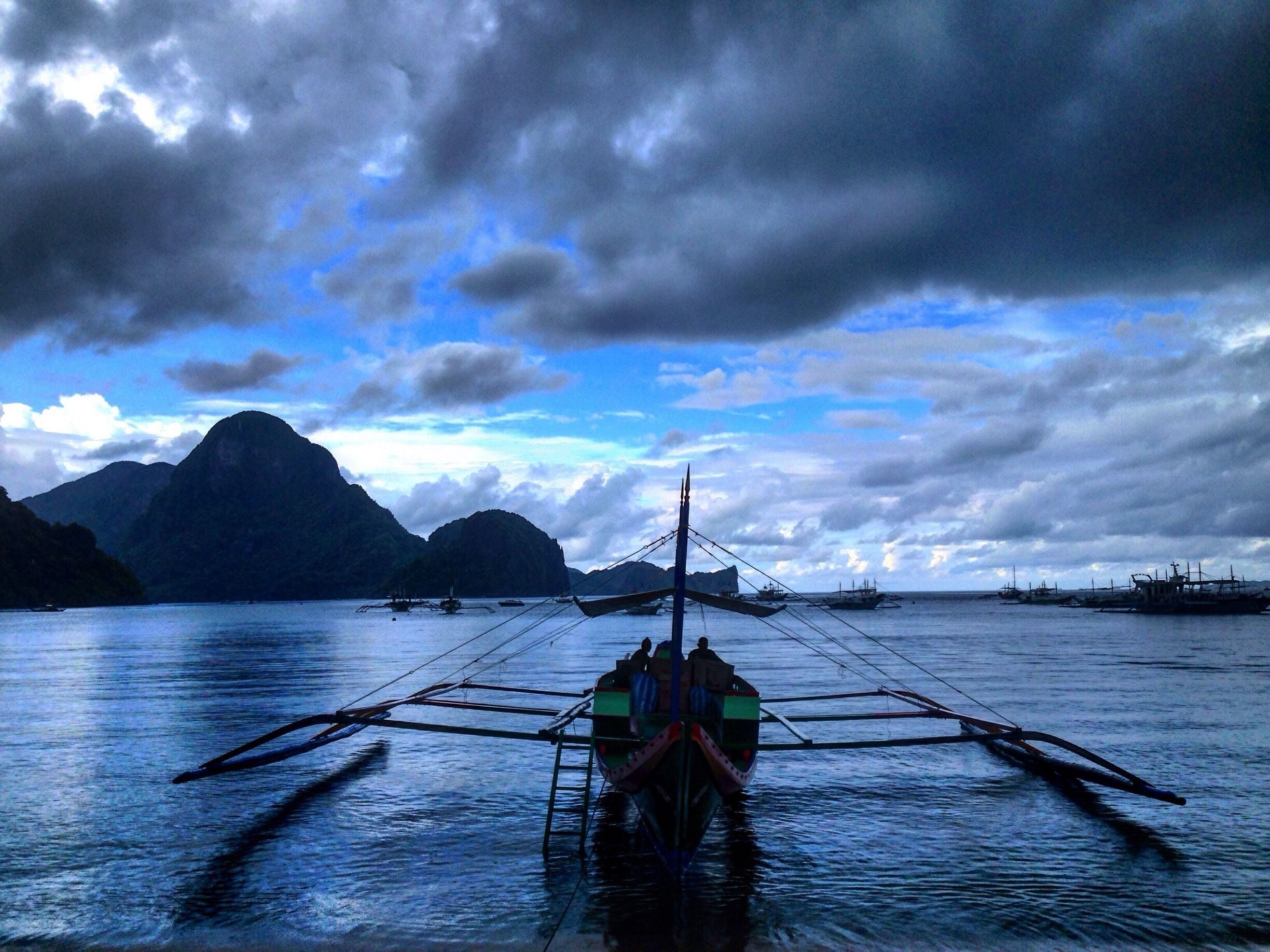 Looming storm and a Bangka in the bay of elnido. 