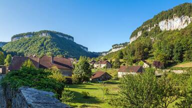 A village with stone buildings, a church, and a mountain in the background.