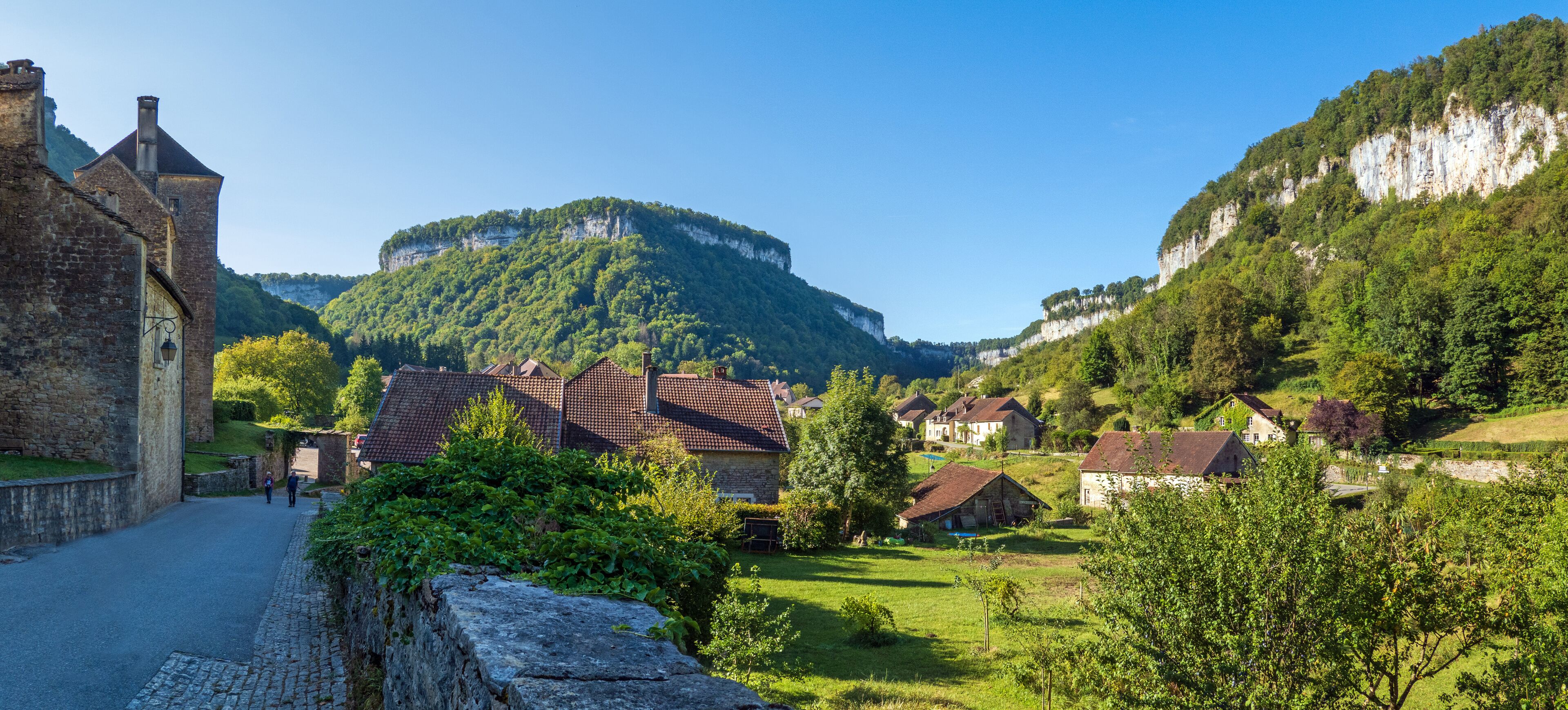 A village with stone buildings, a church, and a mountain in the background.