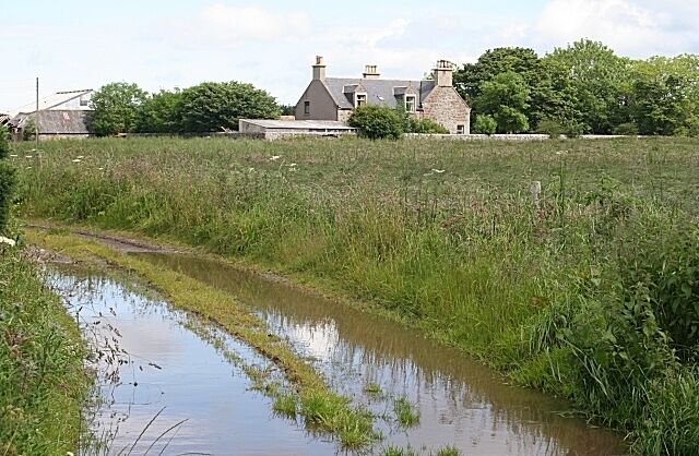 Nether Dallachy A flooded track reflects a spell of blue sky before the next downpour approaches from the west.