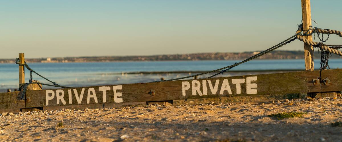 A wooden sign with the word "PRIVATE" written on it, indicating restricted access.