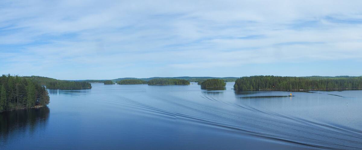 A calm lake surrounded by dense forests and small islands.