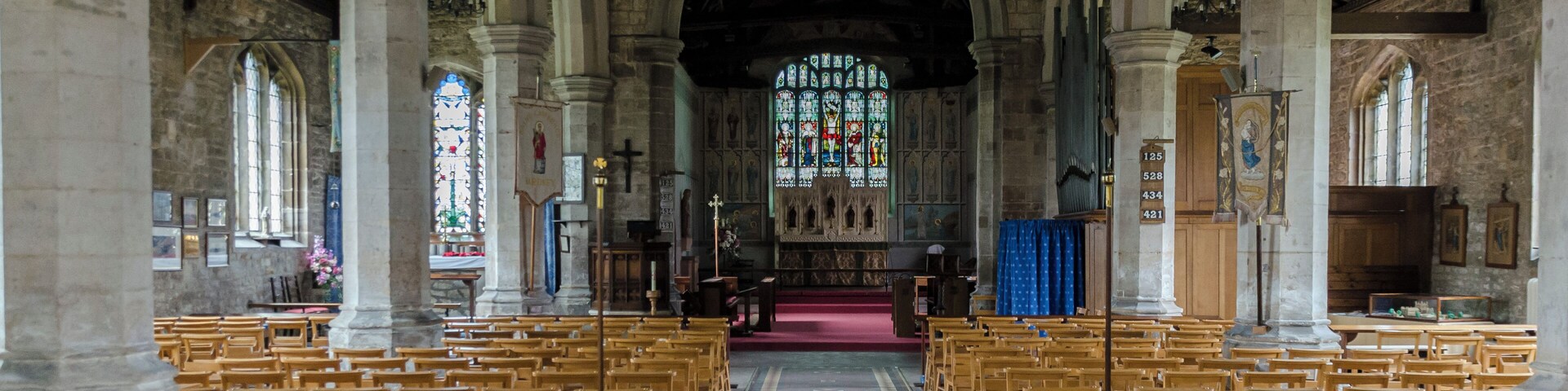Interior. Note the painted chancel. The church was built around 1434, with restoration in the 1870s. It consists of a nave with aisles, western tower, chancel, and north porch. Some parts of the demolished Bardney abbey were used in the church. The tower dates from the late 15th century and has battlements topped with eight pinnacles. It has six bells. The north aisle of 5 bays is from the mid-to late 15th century, the south aisle is of the same date. The piers are octagonal. There is a 17th-century north porch with benches. The chancel is made of brick; Some say the same bricks used to build Tattershall Castle. Inside are murals of 1935 by A. Willets depicting Saints, and there are carved angels in the roof timbers. There is a 19th-century reredos and a 15th century piscina in the south wall. There is also a 14th century figure originally from Bardney Abbey. At the west end of the nave is an incised slab to Abbot Richard Horncastle, died 1508, and three painted wooden panels recording charitable donations. The font and choir stalls are 20th century. There are several architectural fragments from Bardney Abbey on display. The two manual organ is by Cousans. Restoration work was carried out in the 1870s at a cost of some ÂŁ2500, during which the west end of the north aisle was formed into a baptistery. Further restoration was done in the late 1990s.