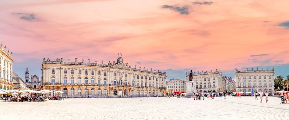 A grand square with ornate buildings and a clear sky.