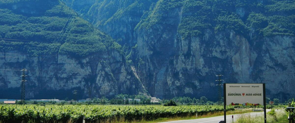 A mountainous landscape with lush greenery and a road in the foreground.