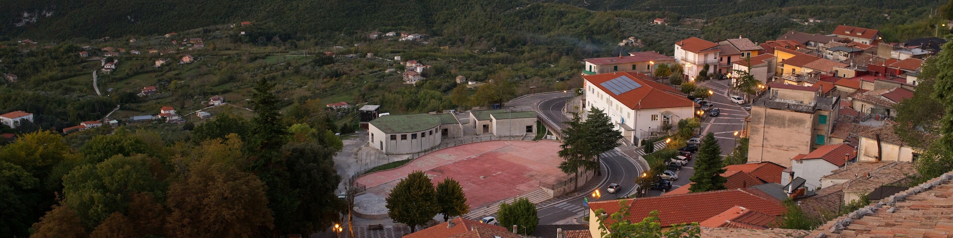 A mountainous town with a prominent church, winding roads, and lush greenery.