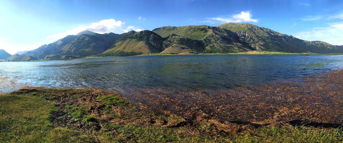 A lake surrounded by mountains with clear skies.