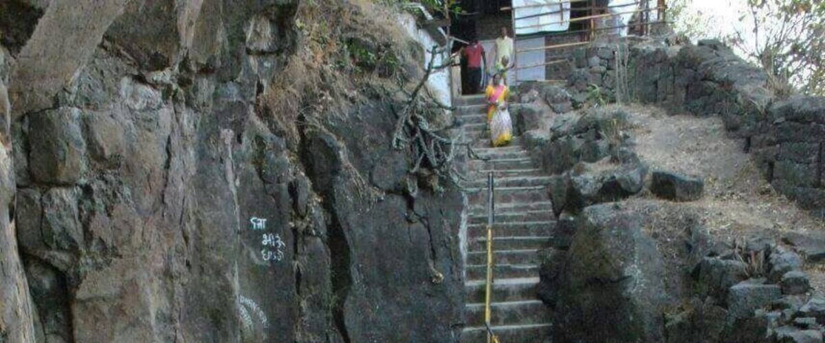 A rocky staircase leading up a mountain with a yellow safety line.
