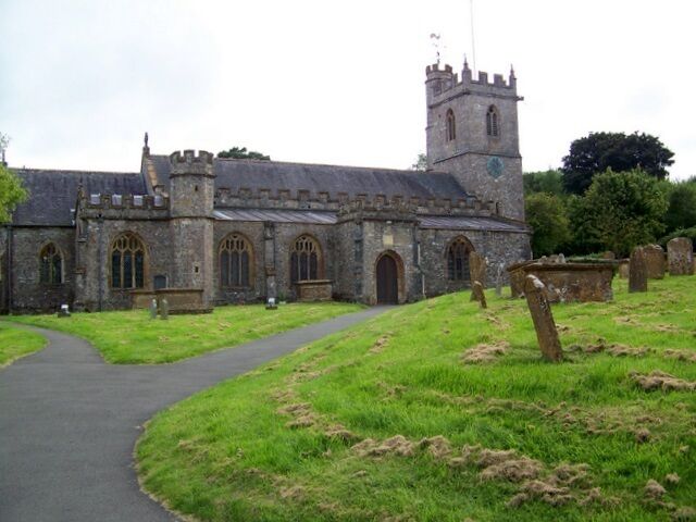 A historic stone church with a tower and arched windows.