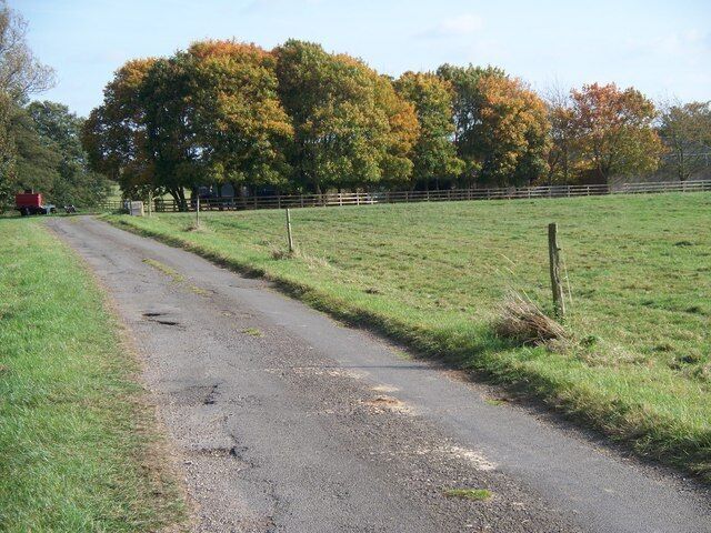 Minor road near Nether Worton The road is gated and runs between Nether Worton and Ilbury Bridge. Behind the trees is a large barn on Newhouse Farm.