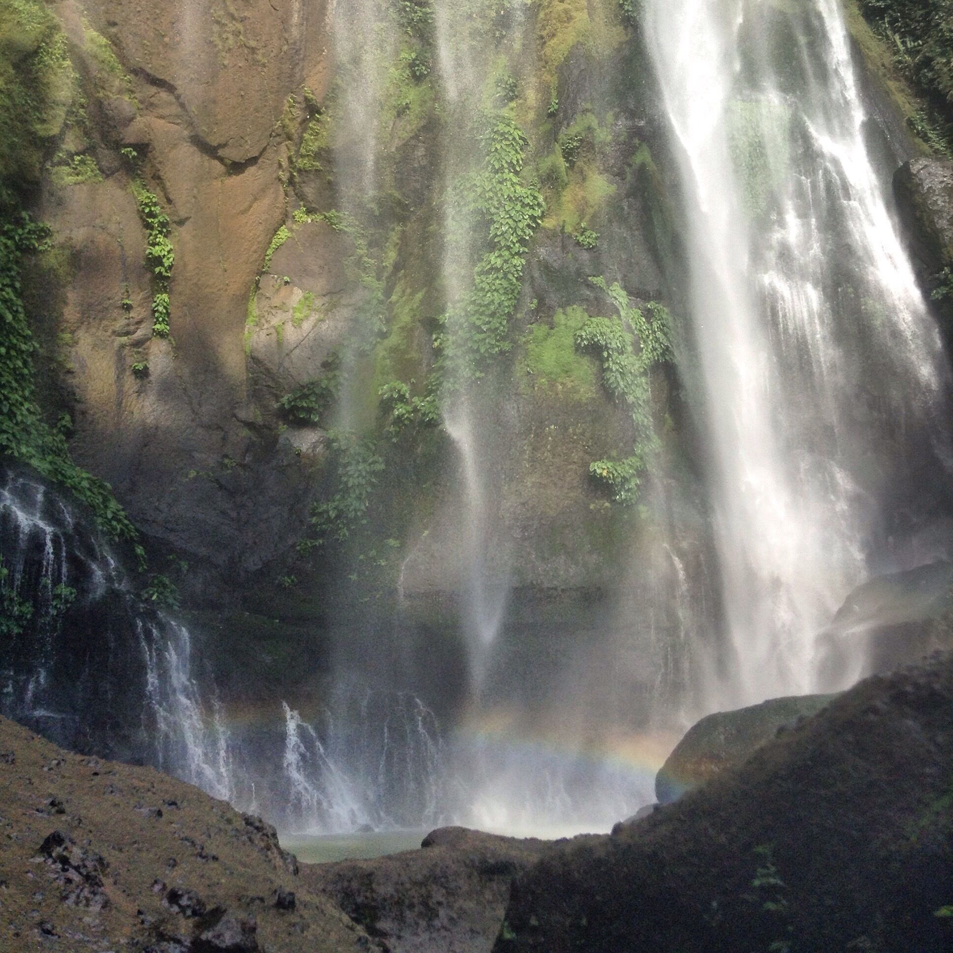 A waterfall cascading down a moss-covered cliff.