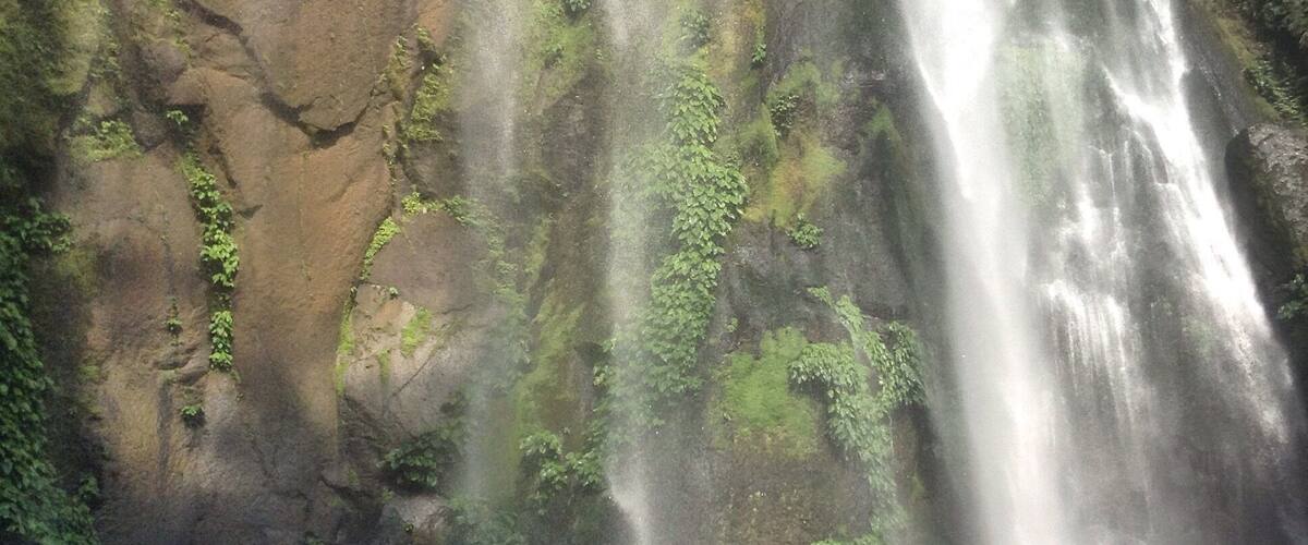 A waterfall cascading down a moss-covered cliff.