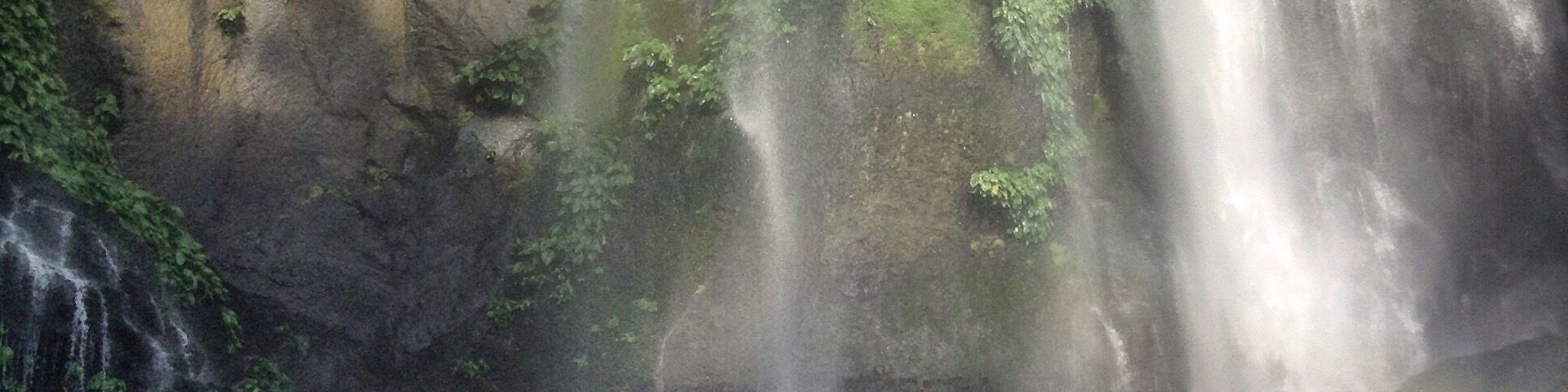 A waterfall cascading down a moss-covered cliff.