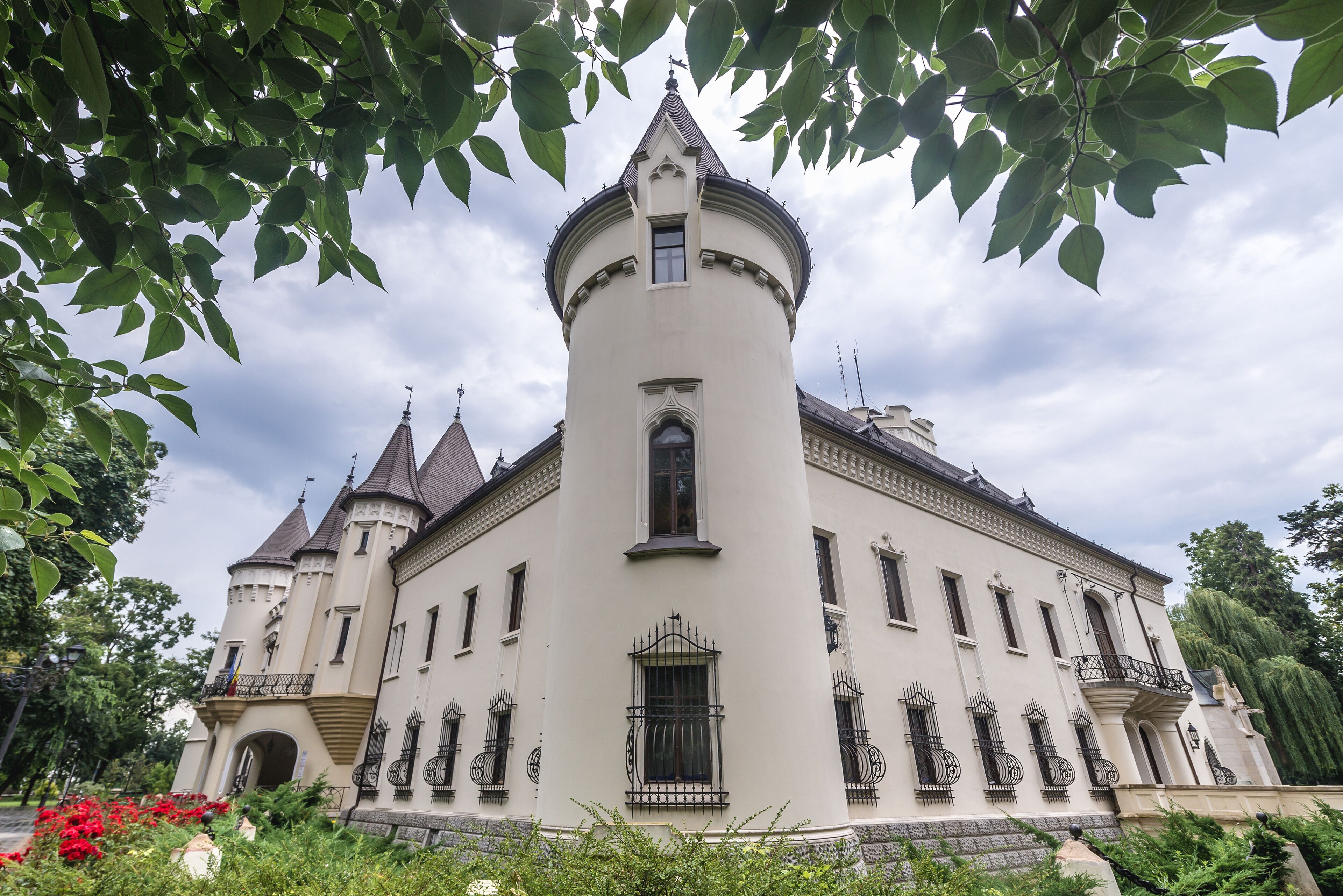 A large, white, castle-like building with multiple towers and a central round tower.
