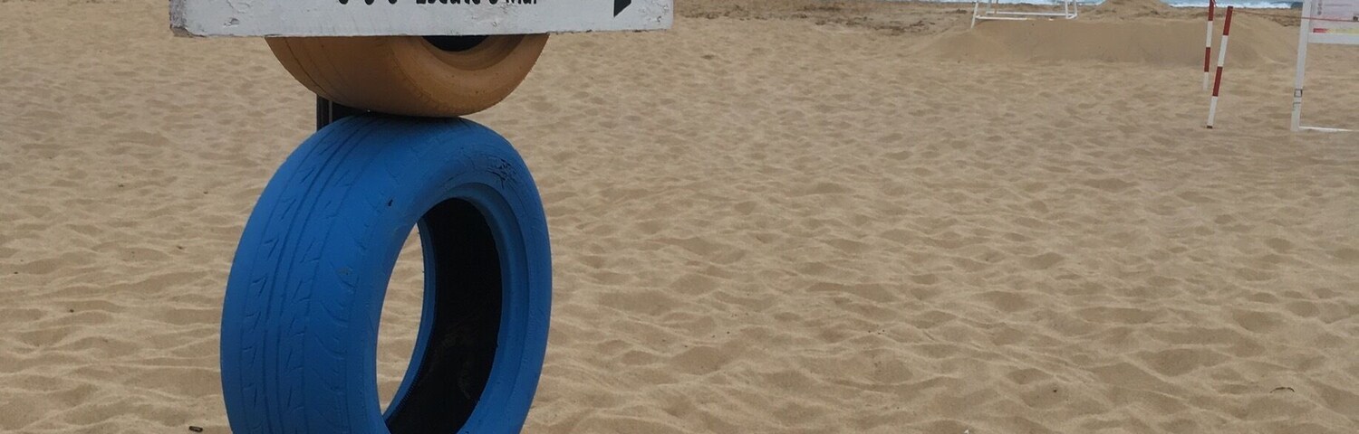 A beach with a sign that reads "THE TIME HAS COME To Listen to the Sea Escute o Mar" and a ladder.