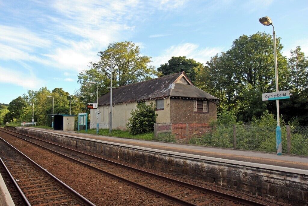 A railway station with a small building labeled 'Cefn-y-bedd' and tracks.