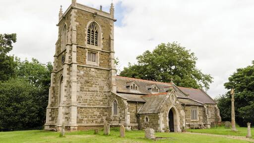 There is no mention of the church in the Domesday book, but there are indications that the first building was early Norman. The church is first documented in 1280. The church is constructed with greenstone with brickwork and ashlar dressings. The roof is slate. There is a western tower, nave with south aisle, chancel, vestry, and south porch. The tower is of three stages dating from the 15th century, it was largely rebuilt in the 19th century. It has a plain parapet and crocketted pinnacles. There is a date stone of 1684 on a plaque which marks the rebuilding of the tower which had collapsed. On the second stage of the tower there is another date stone of 1894 from when the upper part was rebuilt. There a three bay south arcade with octagonal piers from the 15th century. The nave also has three 19th-century dormer windows on the south side which were in inserted in 1911. The chancel was rebuilt in 1870 by James Fowler, the 15th century chancel arch being retained. There is a modern rood loft and screen, the original rood stairs are still present. Either side of the rood are two wooden carved Angels, probably dating from the 15th century and taken from Louth church. In the 19th century porch there is a Norman holy water stoup. There is a 14th century octagonal font set on a Minton tile dias. In 1877 the church underwent major restoration which included new roofs, porch, installation of heating, new floors plus other improvements. This was not finished until 1894 due to financial issues.