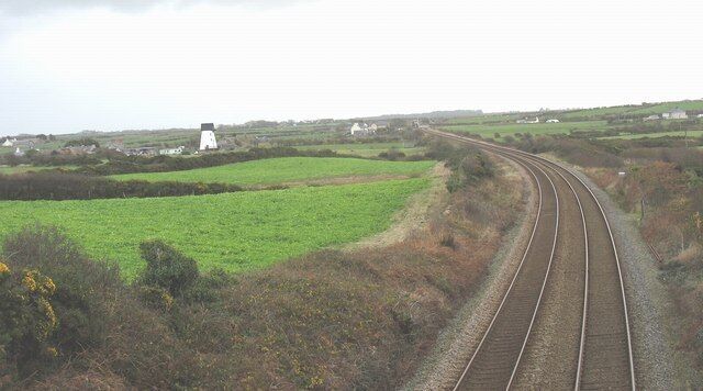 Railway line east of Glan-gors bridge Melin y Bont mill and Ty Croes Station (with the level-crossing gates open to road traffic) can be seen in the distance.
