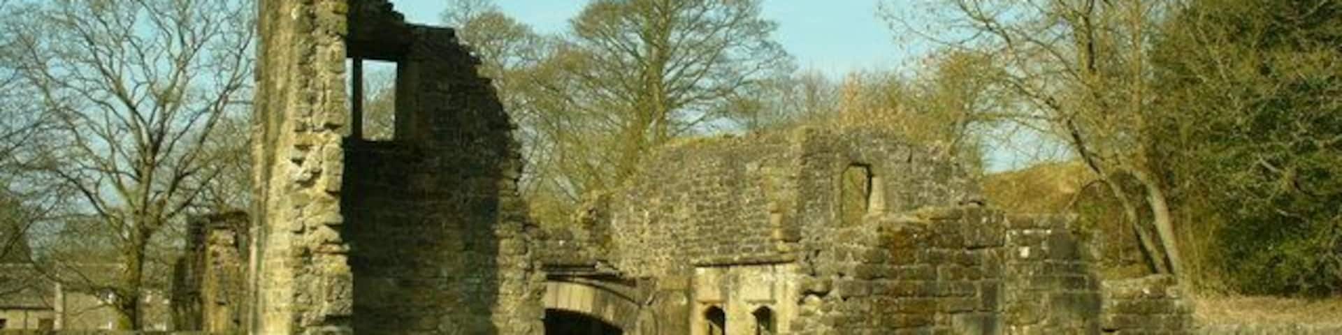 A stone ruin with arches and a tall, narrow tower.