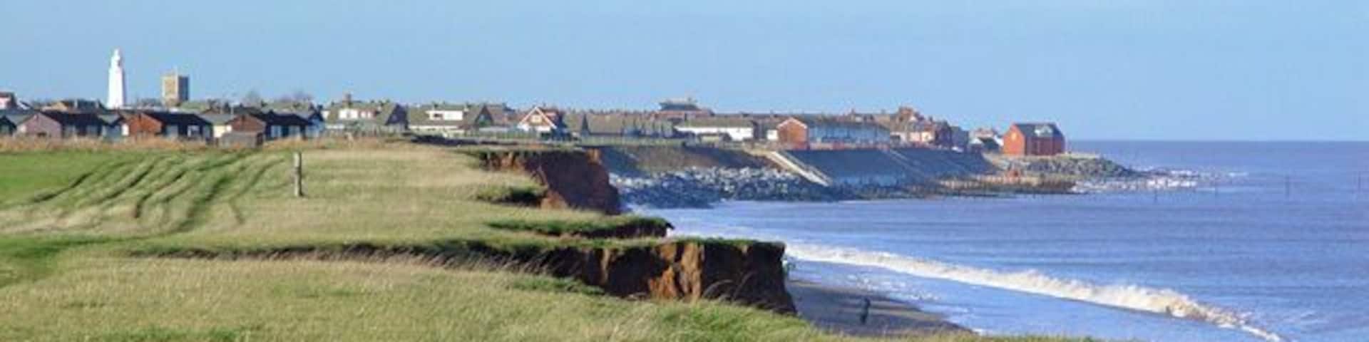 Clifftop Path south of Withernsea, East Riding of Yorkshire, England. Each year a little more falls into the sea, and each year Withernsea sticks out a little further. Note the lighthouse and church in the distance.