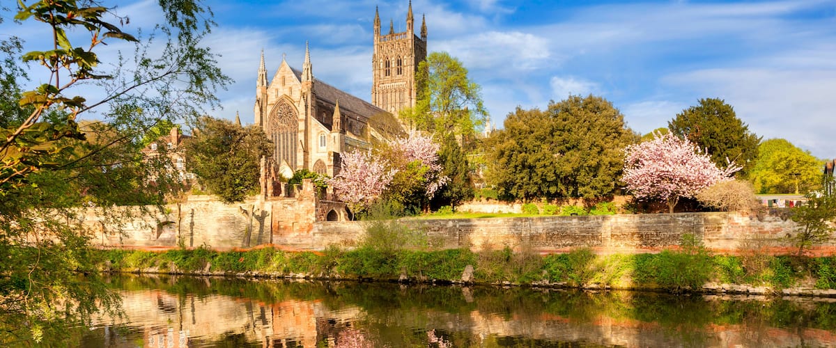Worcester Cathedral on a sunny spring morning, with cherry blossom in bloom, and a reflection in the River Severn.