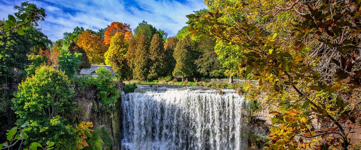 Une cascade entourée d'un feuillage automnal.