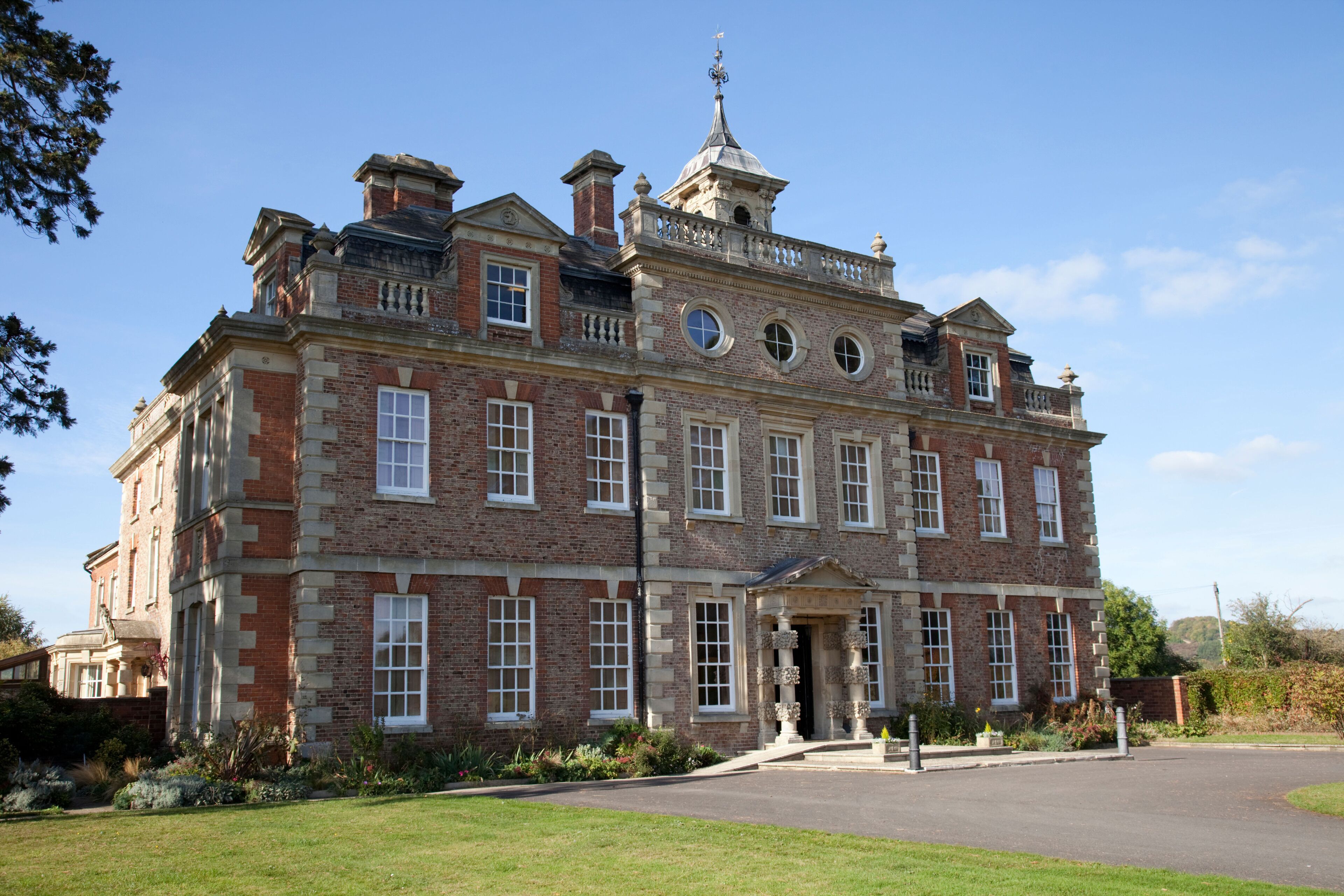 A large, historic brick building with multiple windows and a prominent entrance.