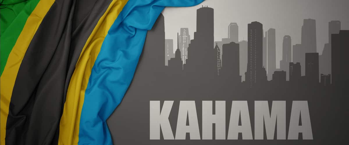 The flag of Haiti draped over a city skyline silhouette with the word "KAHAMA" below.