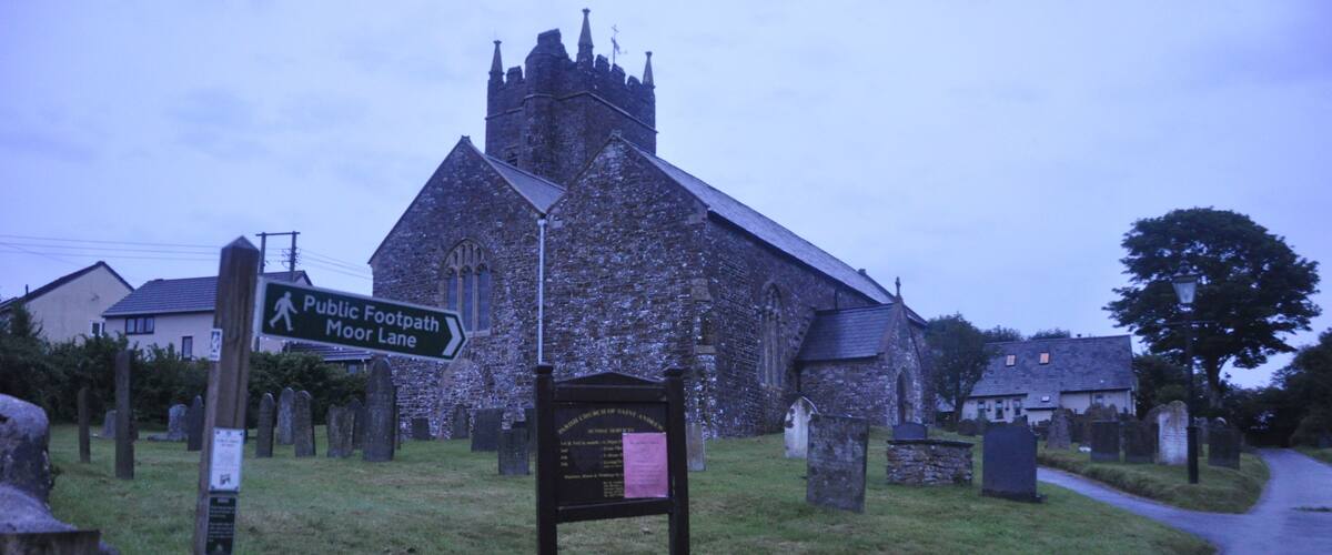 A church with a sign for the public footpath Moor Lane.