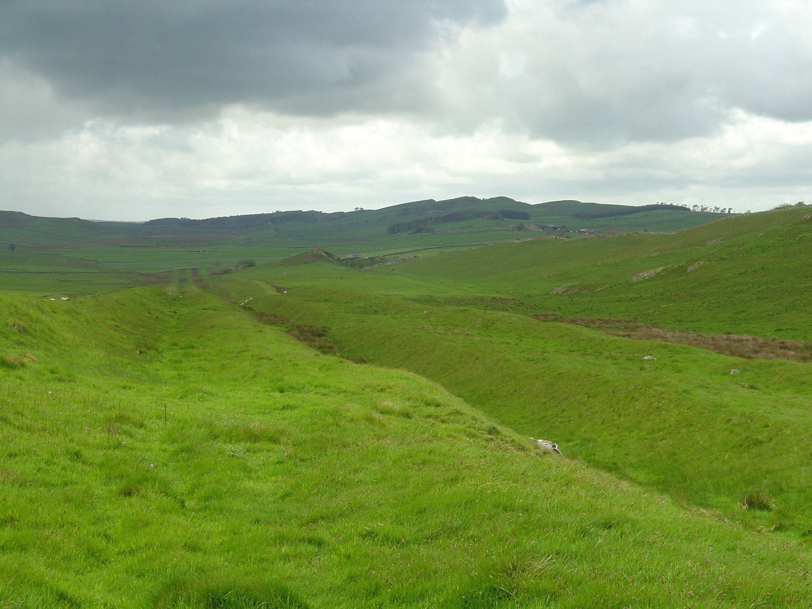 Vallum at Hadrian's Wall, near Milecastle 42 looking west. The wall can be seen on the ridge to the right.