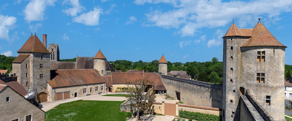 A historic castle with multiple towers and a well-maintained courtyard.