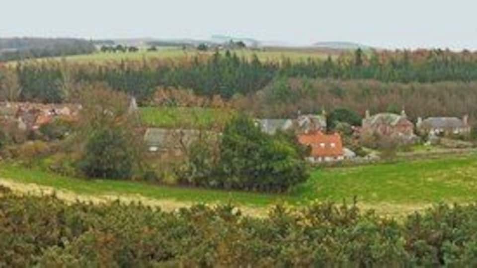 Garvald panorama from Law Knowes This is a linear village in a hidden valley below the Lammermuirs. Several of the buildings are listed and the village and its environs have been designated as a conservation area.