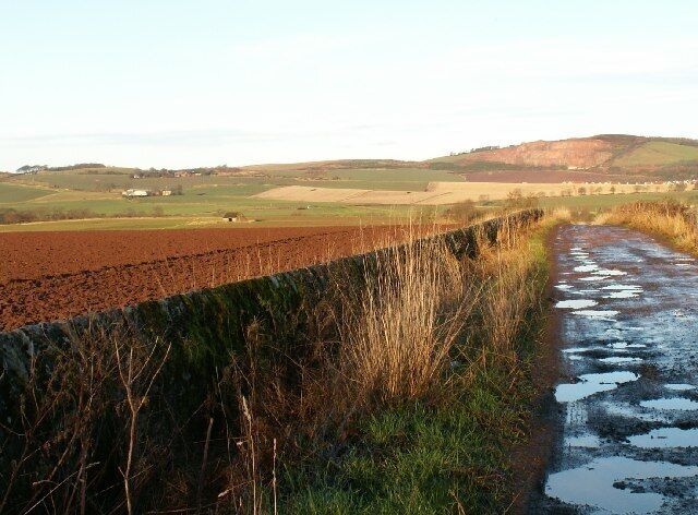 Farmland and road by Seggiehill. An overview of the NW corner of the square from the top end of the Seggiehill farm road. In the far distance at about 3kms distance is Lacklaw, 190mts and Balmullo Redstone quarry.