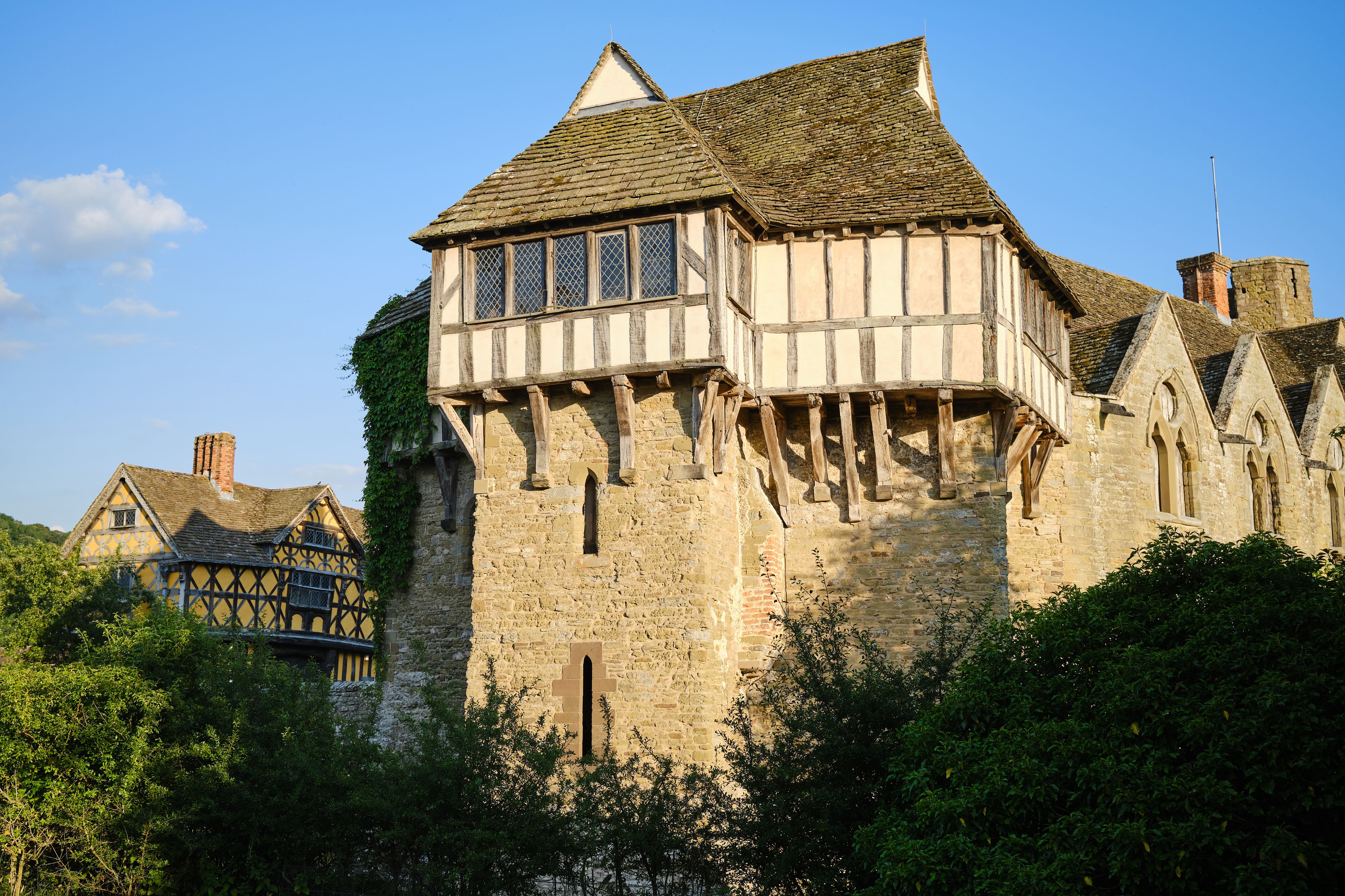 A historic half-timbered building with a steeply pitched roof and a small tower.