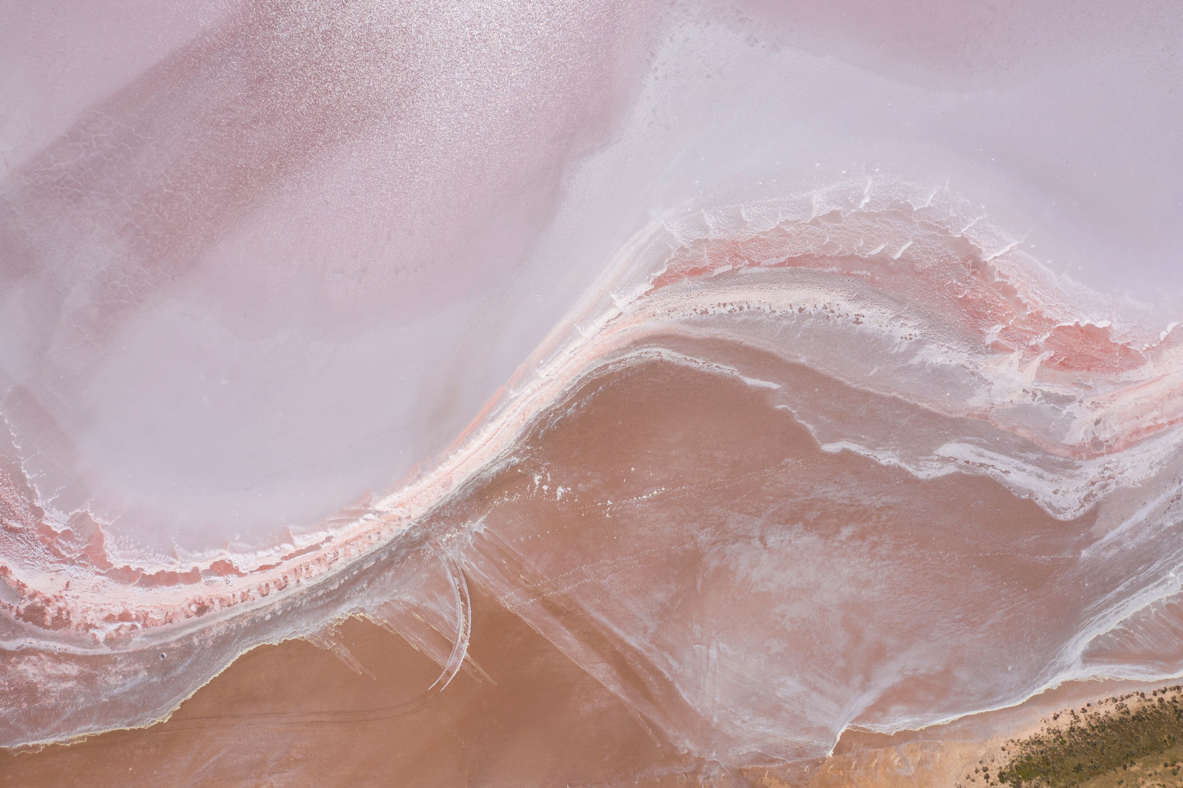 A pink salt flat with a winding river.
