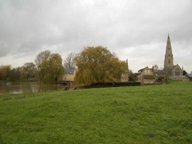 The Old Mill at Olney This view shows the setting of the Mill House behind the willow tree and beside the swollen River Great Ouse at Olney. The nearby church of St Peter & St Paul is also visible. The mill itself burnt down on 16 November 1964 and was previously destroyed by fire on 3 January 1878.