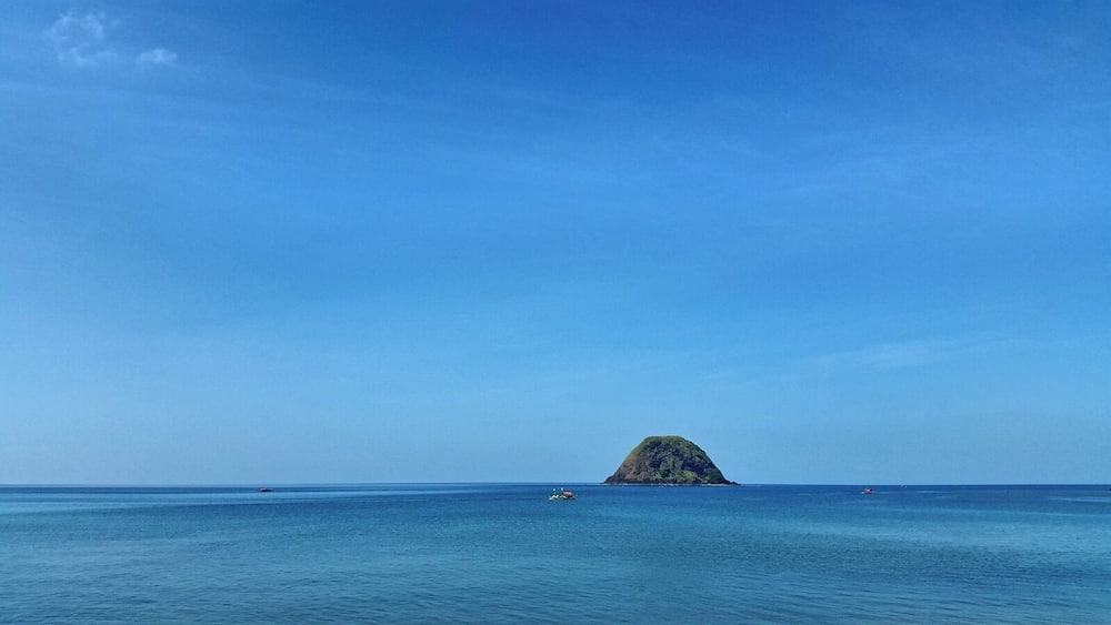Ein klares blaues Meer mit einer kleinen Insel in der Ferne.