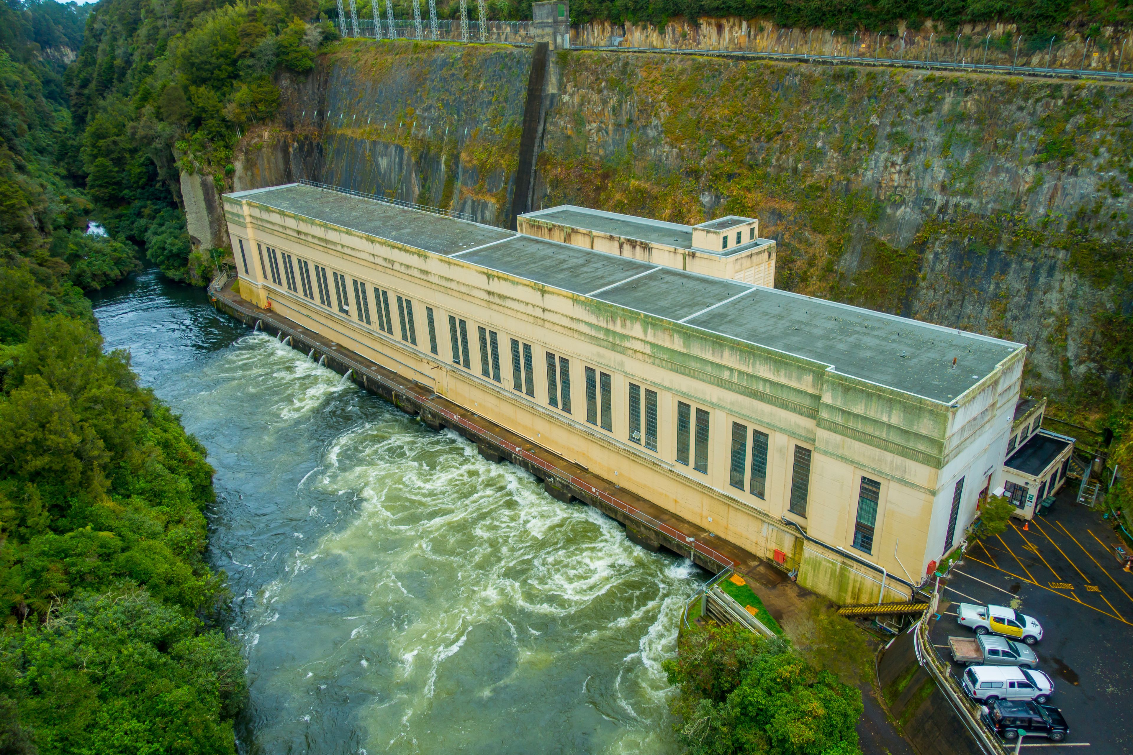 Een dam met een rivier erdoorheen, omringd door groen.