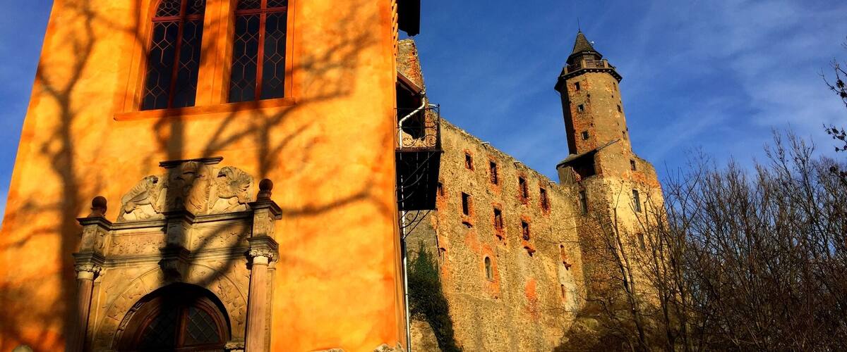 A church with a yellow facade and a stone tower.