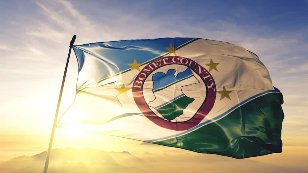 Bomet county of Kenya flag waving on the top sunrise mist fog