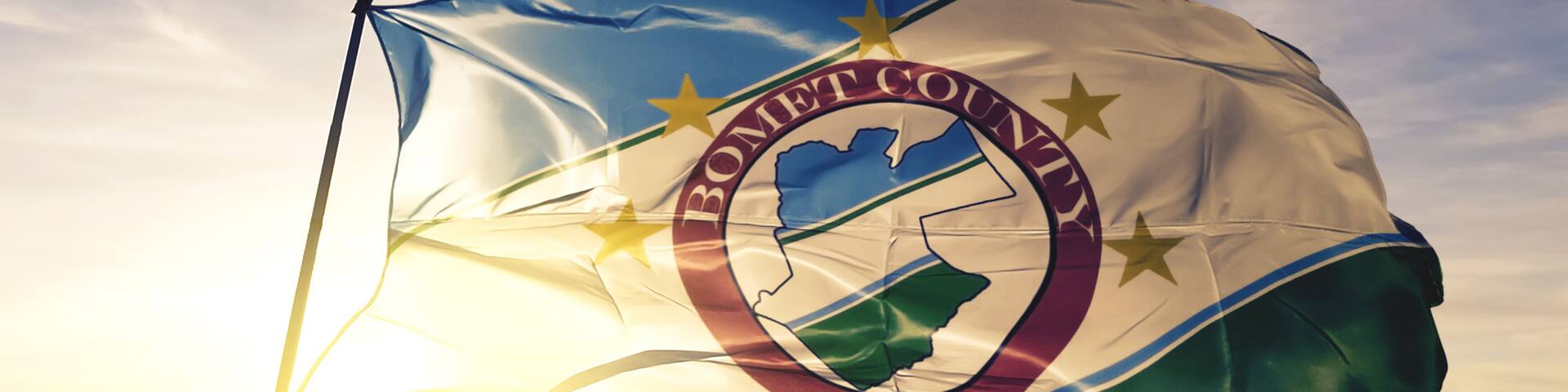 Bomet county of Kenya flag waving on the top sunrise mist fog