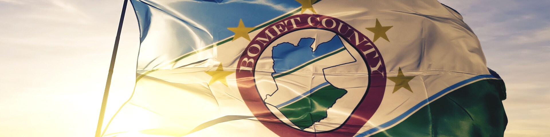 Bomet county of Kenya flag waving on the top sunrise mist fog