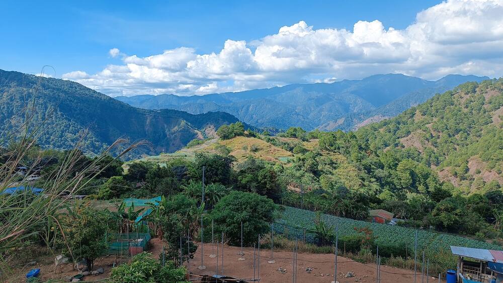 A mountainous landscape with terraced fields and a clear sky.
